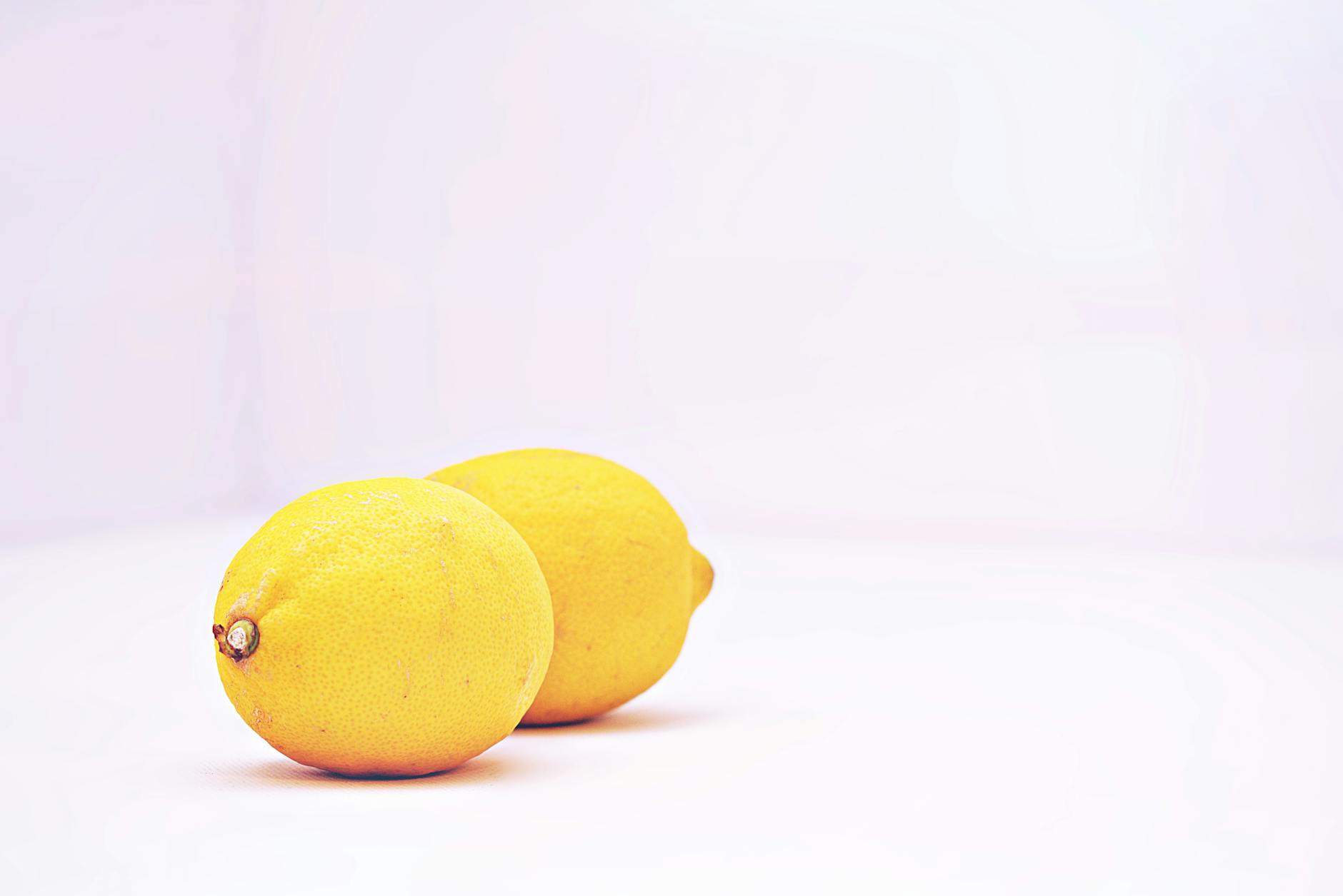 Two hands holding silicone vibrators against a soft pastel background, representing partnership and shared pleasure