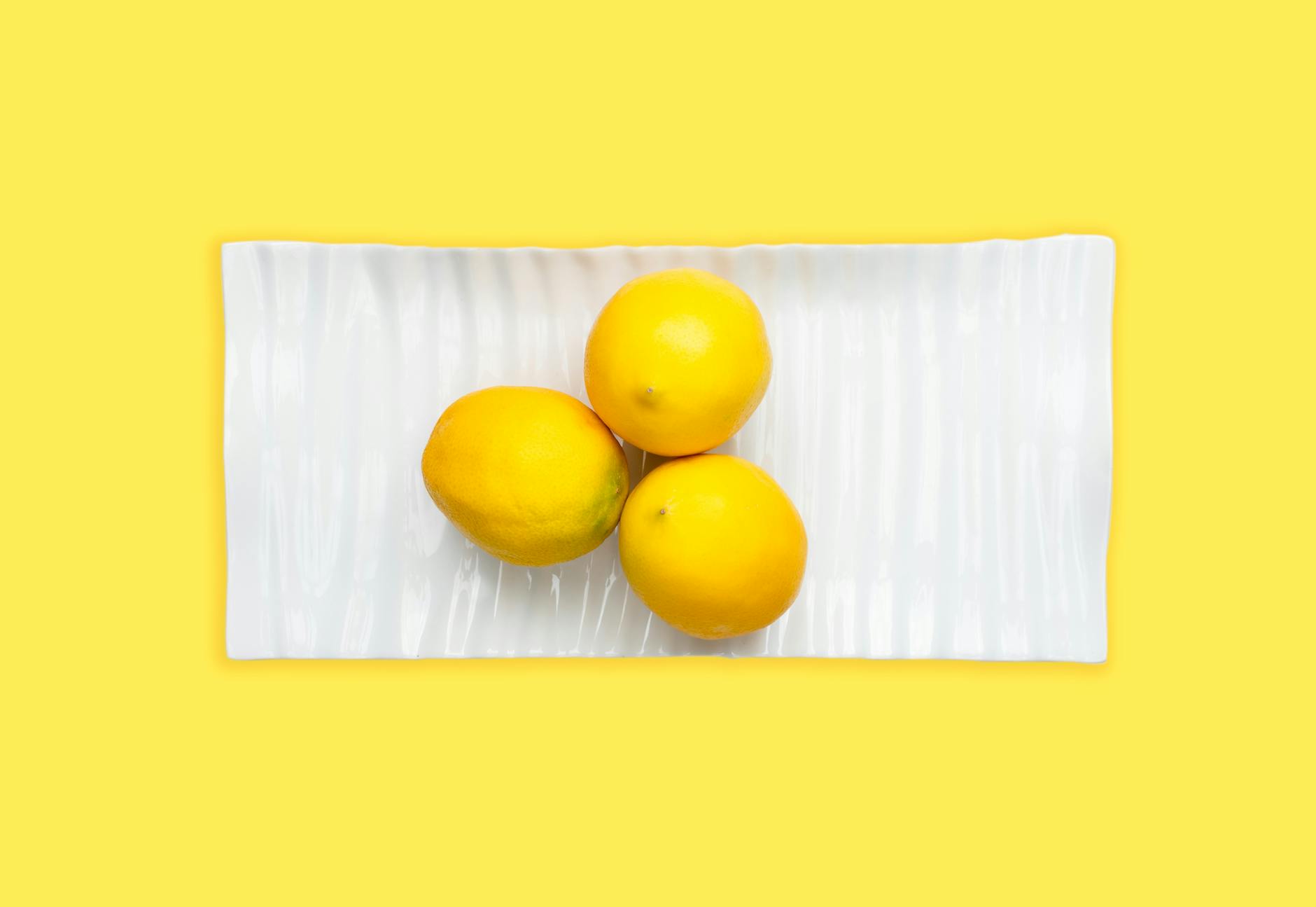 Bright yellow lemons arranged on pastel green background, symbolizing fresh renewal and recovery