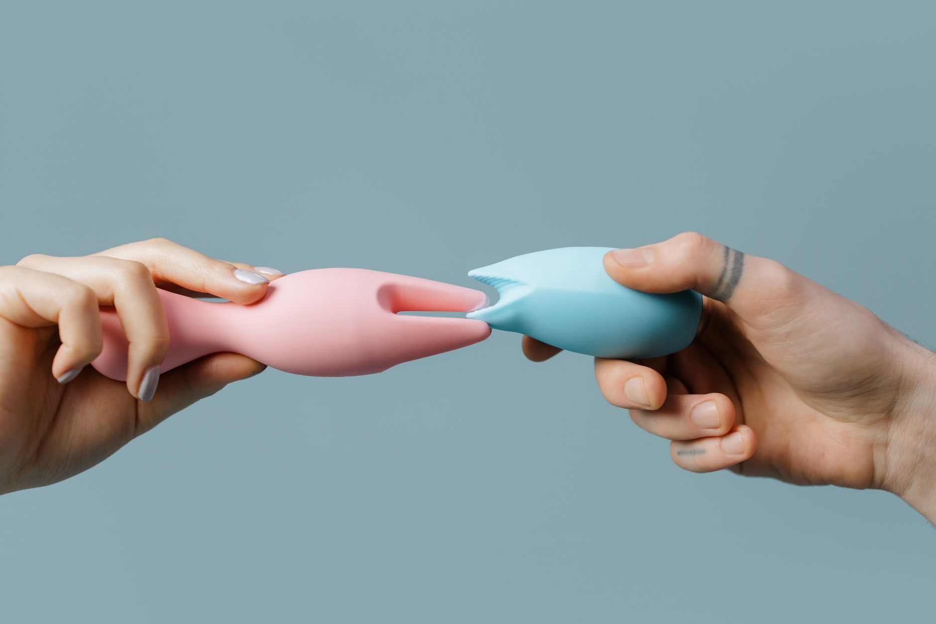 Mulher segurando vibrador rosa com livros ao fundo, representando autoconhecimento e retomada do prazer