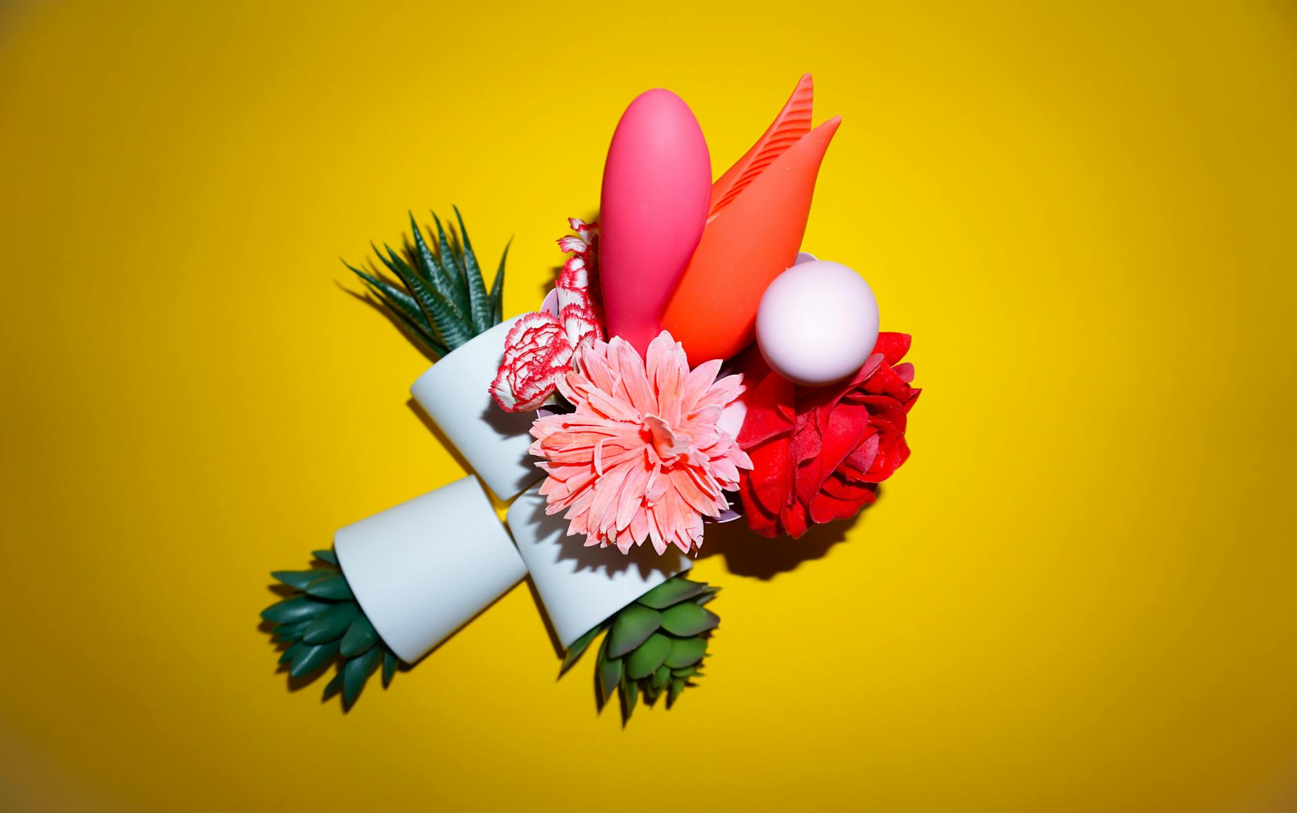 Vibrador de silicone amarelo cercado por bananas descascadas em fundo amarelo, simbolizando prazer e sensualidade