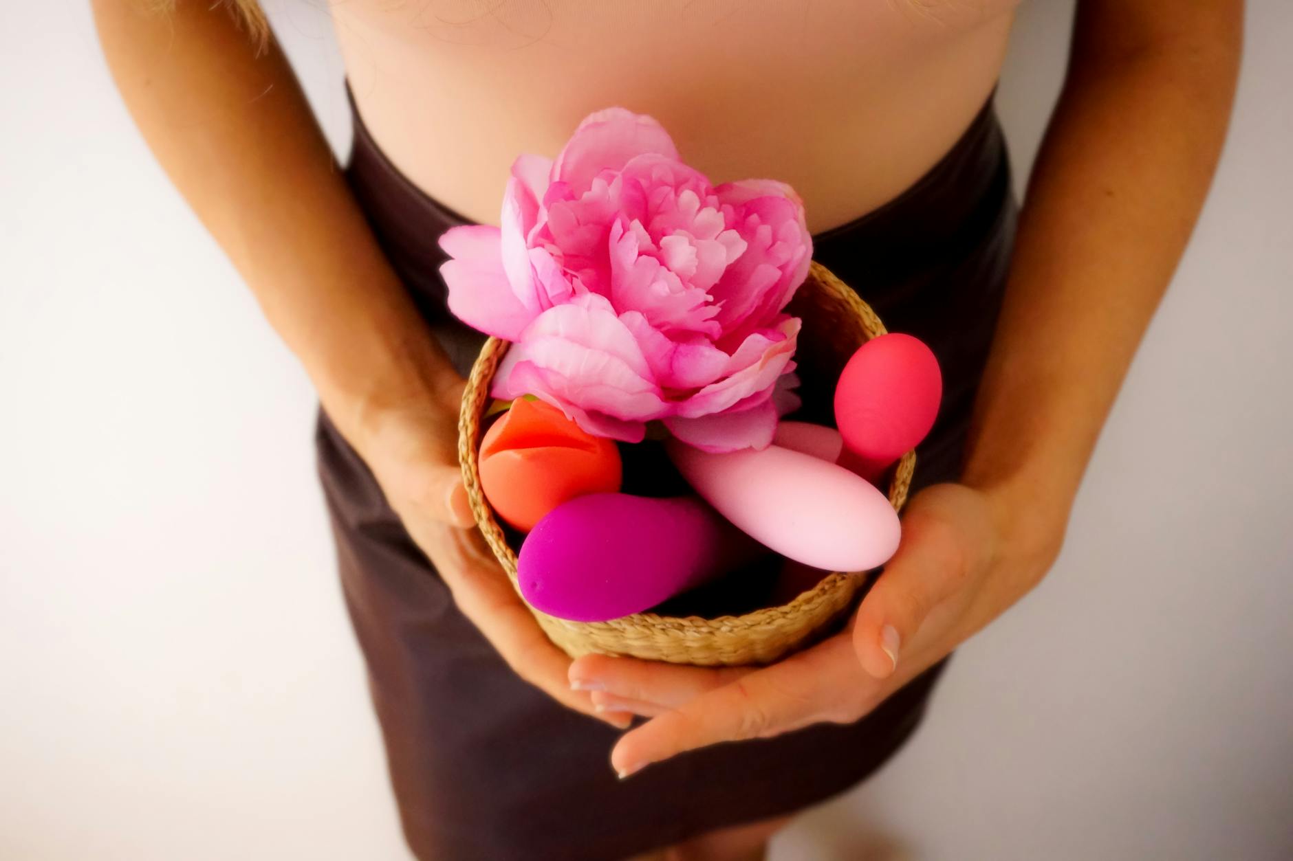 Mulher segurando vibradores rosa e azul em atitude contemplativa